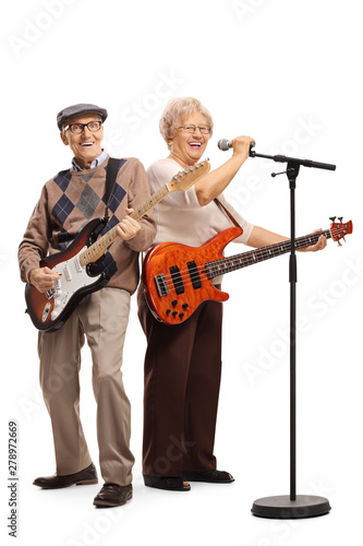 Senior couple with electric guitars singing on a microphone © Ljupco Smokovski