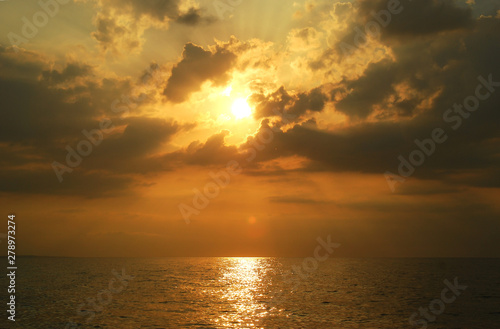 Beautiful cloudy sunset over the sea with the beams shining through the clouds