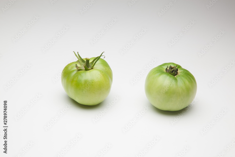 Tomates verdes sobre fondo blanco