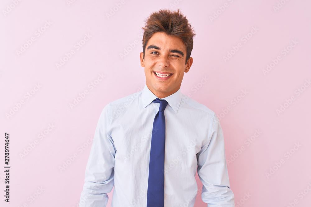 Young handsome businessman wearing shirt and tie standing over isolated pink background winking looking at the camera with sexy expression, cheerful and happy face. Young handsome businessman wearing shirt and tie standing over isolated pink background winking looking at the camera with sexy expression, cheerful and happy face.