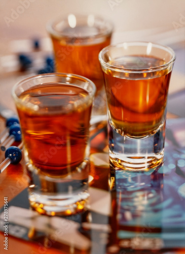 3 shot glasses full of whisky with a shallow depth of field.