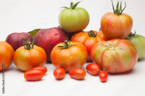 Nectarinas  tomates maduros y tomates cherri sobre un fondo blanco. Los productos han sido traidos de un huerto ecol  gico  cultivados sin productos qu  micos ni pesticidas.