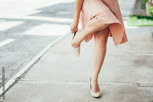 Foto Woman suffering from leg pain outdoors because of uncomfortable shoes