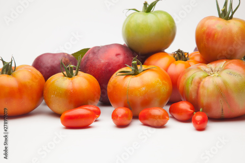 Fototapeta Naklejka Na Ścianę i Meble -  Nectarinas, tomates maduros y tomates cherri sobre un fondo blanco. Los productos han sido traidos de un huerto ecológico, cultivados sin productos químicos ni pesticidas.