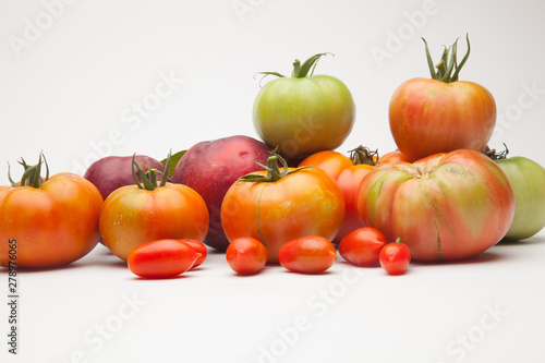 Nectarinas  tomates maduros y tomates cherri sobre un fondo blanco. Los productos han sido traidos de un huerto ecol  gico  cultivados sin productos qu  micos ni pesticidas.