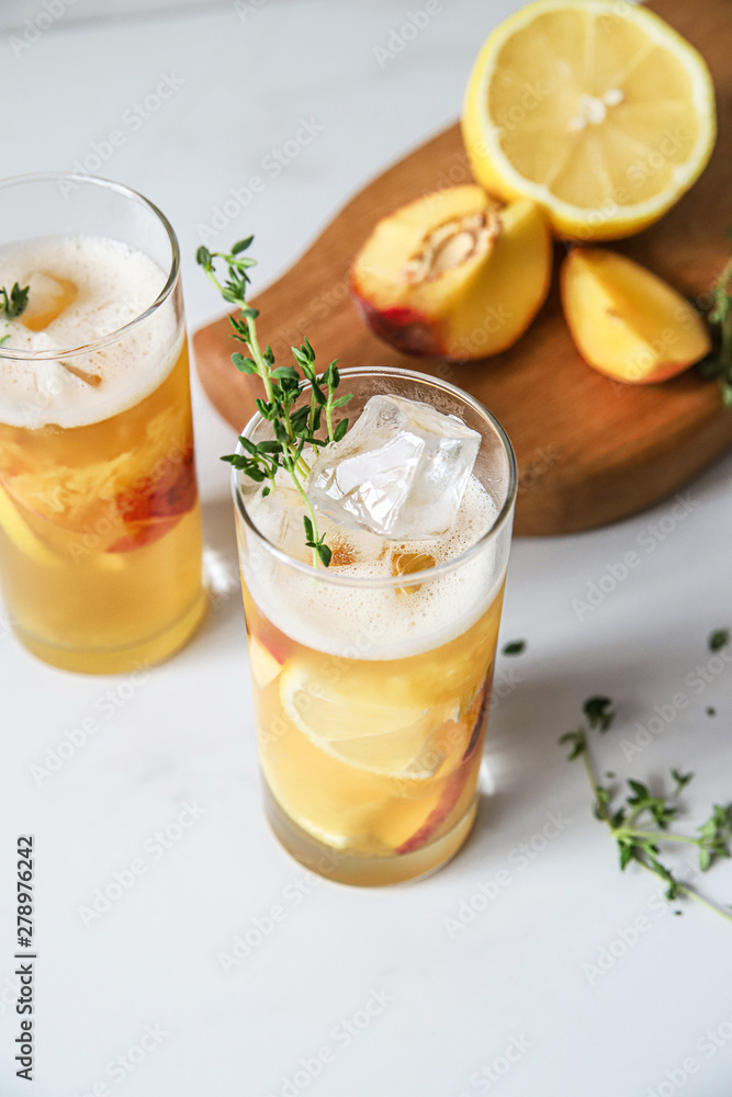 Fototapeta premium Fresh peach lemonade on light marble background. Top view