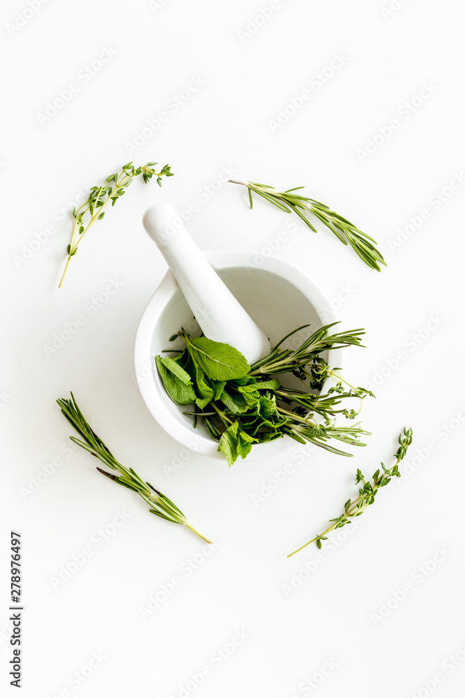 Homeopathy with leaves and healing herbs for making oil on white background top view