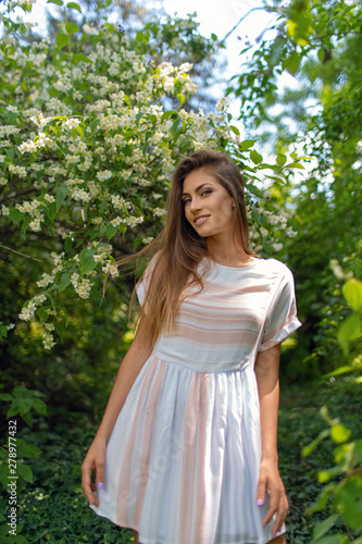 Portrait of a young beautiful girl in a white dress on a green background