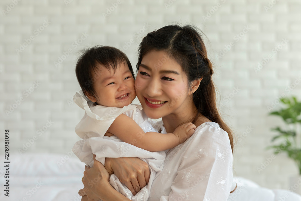 Happy Beauty mother Holding Cute Sweet Adorable Asian Baby wearing white dress sitting on Carpet smiling and playing with happiness emotional in cozy bedroom,Healthy Baby Concept Happy Beauty mother Holding Cute Sweet Adorable Asian Baby wearing white dress sitting on Carpet smiling and playing with happiness emotional in cozy bedroom,Healthy Baby Concept