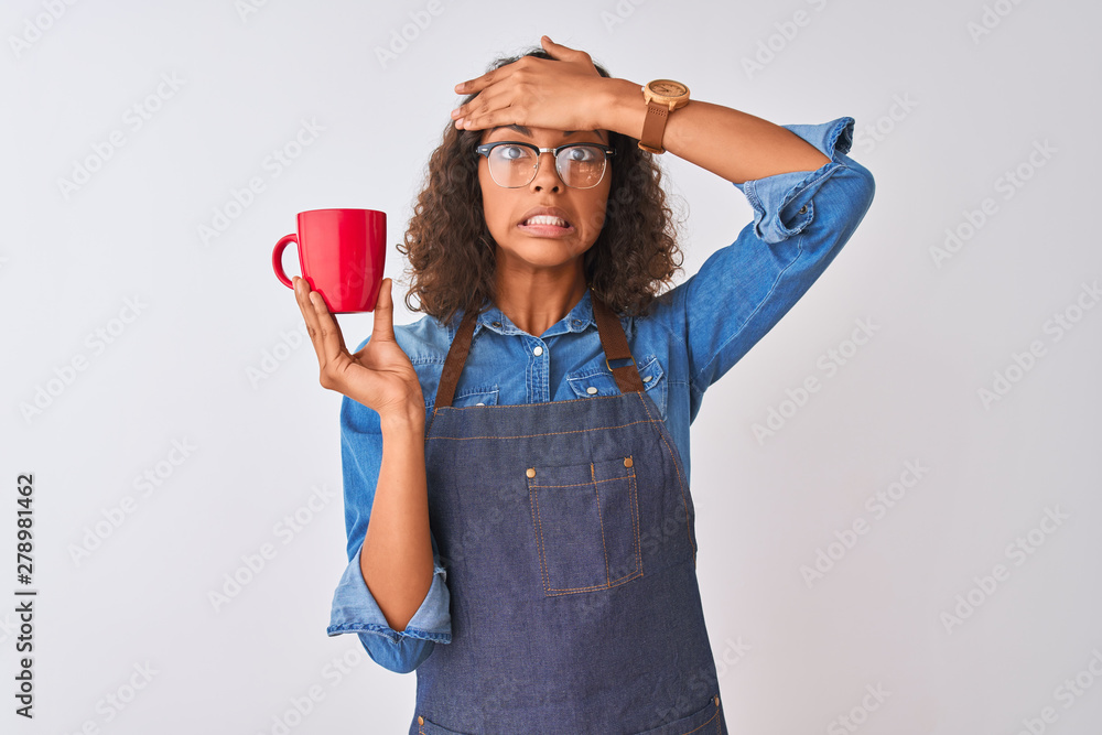 Brazilian barista woman wearing apron drinking cup of coffee over isolated white background stressed with hand on head, shocked with shame and surprise face, angry and frustrated. Fear and upset Brazilian barista woman wearing apron drinking cup of coffee over isolated white background stressed with hand on head, shocked with shame and surprise face, angry and frustrated. Fear and upset