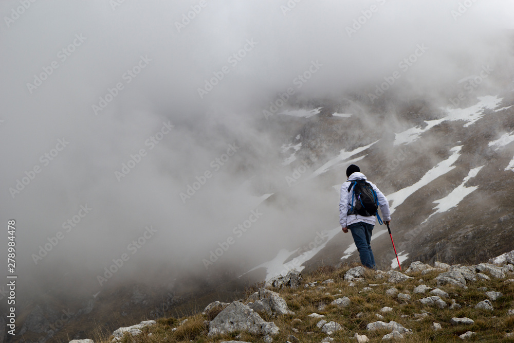 hiker on mountain peak in matese park and fog hiker on mountain peak in matese park and fog