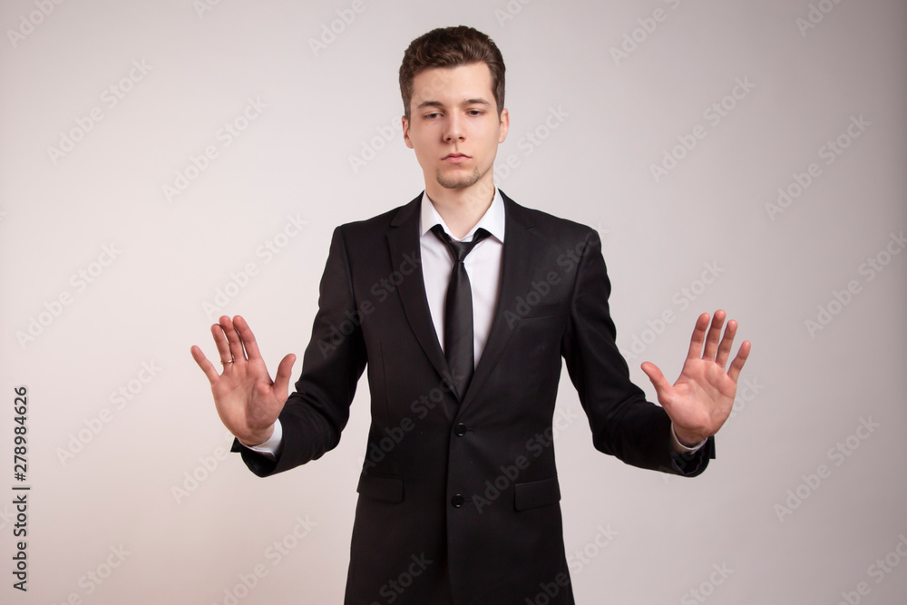 A married man with a ring on his finger expresses protest with his hands. In a black suit on a white background. Do not come, do not touch, I have problems. A married man with a ring on his finger expresses protest with his hands. In a black suit on a white background. Do not come, do not touch, I have problems.