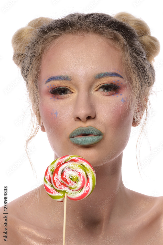 Portrait of a young beautiful girl with a lollipop. Creative makeup. Green lips.On a white background