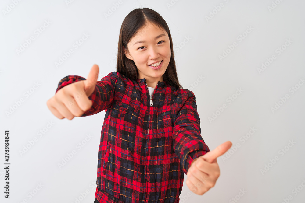 Young chinese woman wearing casual jacket standing over isolated white background approving doing positive gesture with hand, thumbs up smiling and happy for success. Winner gesture. Young chinese woman wearing casual jacket standing over isolated white background approving doing positive gesture with hand, thumbs up smiling and happy for success. Winner gesture.