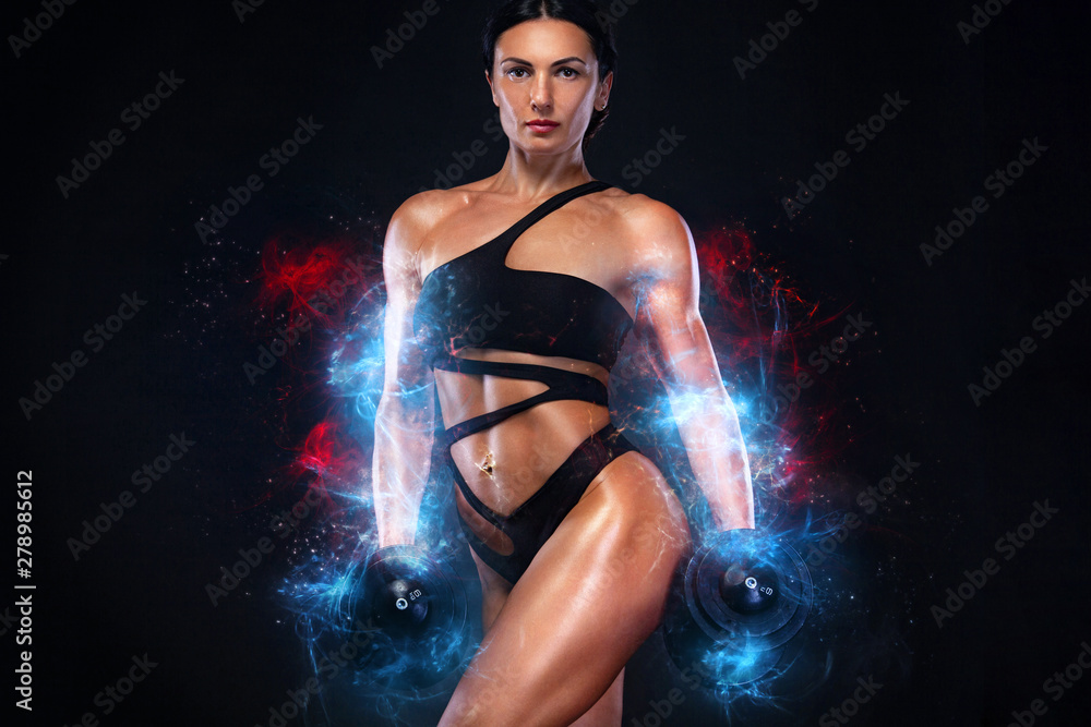 Strong muscular bodybuilder athletic woman pumping up muscles with dumbbells on black background. Workout bodybuilding and energy concept.