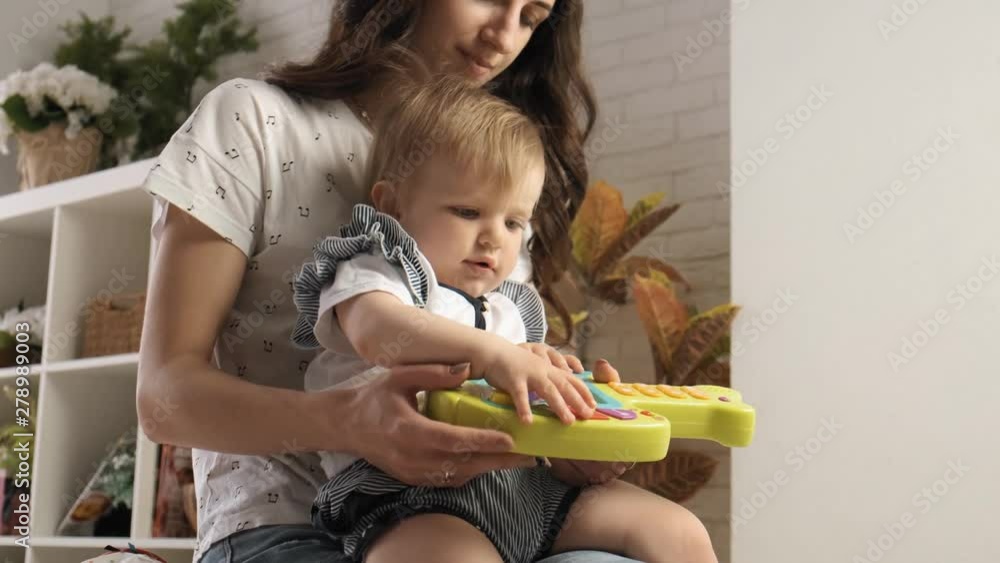 Nanny teachs baby girl how to play toys in the private kindergarten Nanny teachs baby girl how to play toys in the private kindergarten