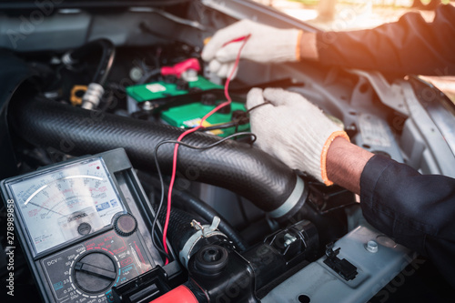 Car service ,fitting a car battery with wrench / soft focus picture