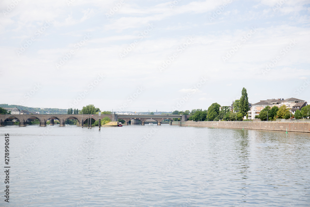 Obraz premium weitblick auf die brücke und das rheinufer unter blauem himmel in koblenz und umgebung fotografiert während einer schiffstour auf dem rhein in koblenz und umgebung