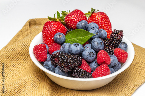 Bowl full of farm fresh berries on a cloth.