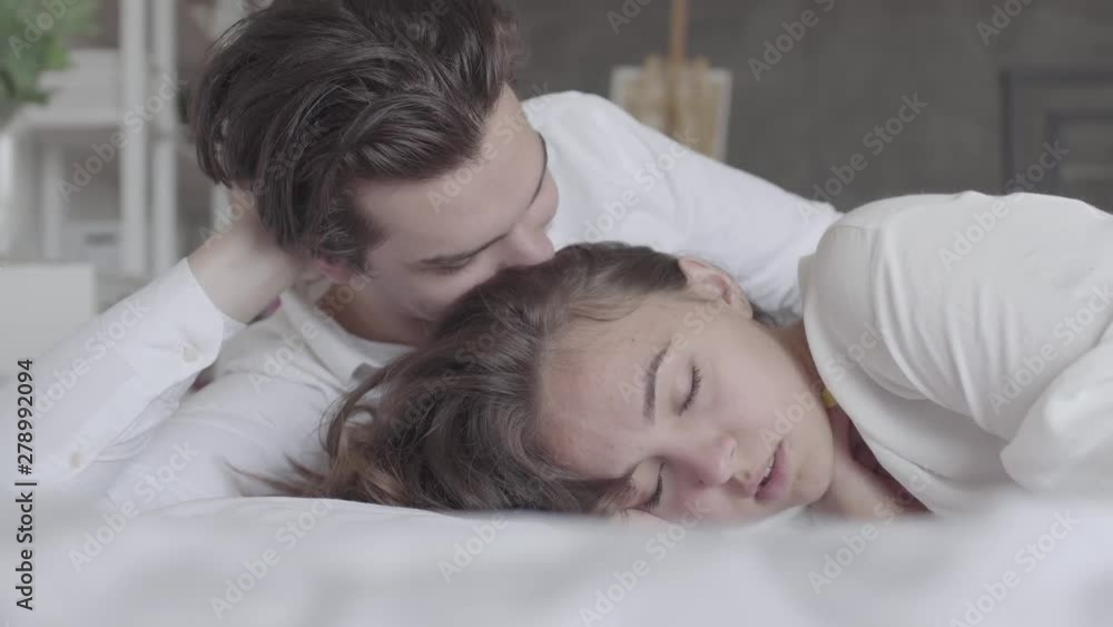 Upset offended girl ignoring boyfriend, turned away, misunderstanding, conflict. Young couple lying in bed close-up. Upset offended girl ignoring boyfriend, turned away, misunderstanding, conflict. Young couple lying in bed close-up.