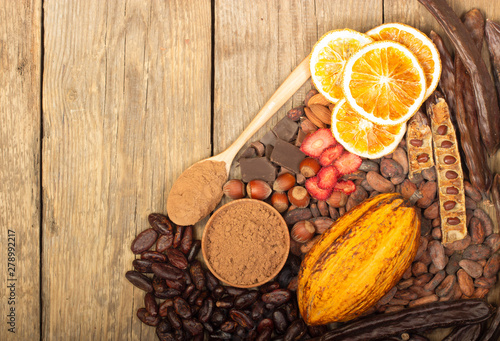 cacao pods, carob pods and dried fruits on wooden background