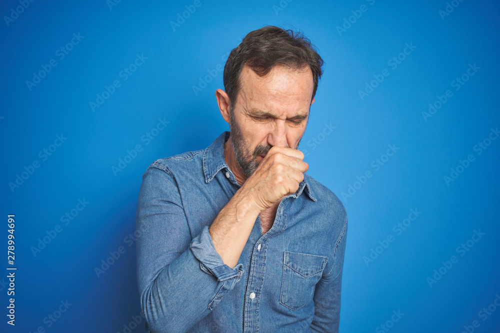 Handsome middle age senior man with grey hair over isolated blue background feeling unwell and coughing as symptom for cold or bronchitis. Healthcare concept. Handsome middle age senior man with grey hair over isolated blue background feeling unwell and coughing as symptom for cold or bronchitis. Healthcare concept.
