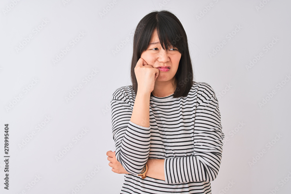 Young beautiful chinese woman wearing black striped t-shirt over isolated white background looking stressed and nervous with hands on mouth biting nails. Anxiety problem. Young beautiful chinese woman wearing black striped t-shirt over isolated white background looking stressed and nervous with hands on mouth biting nails. Anxiety problem.