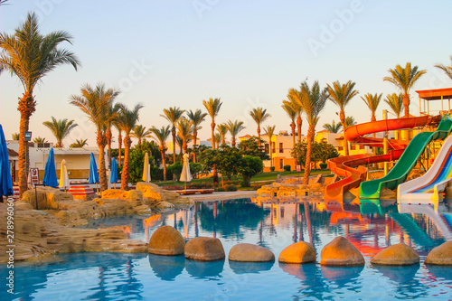 Water colorful rainbow slides with swimming pool in the hotel at dawn. Water sport intertainment photo