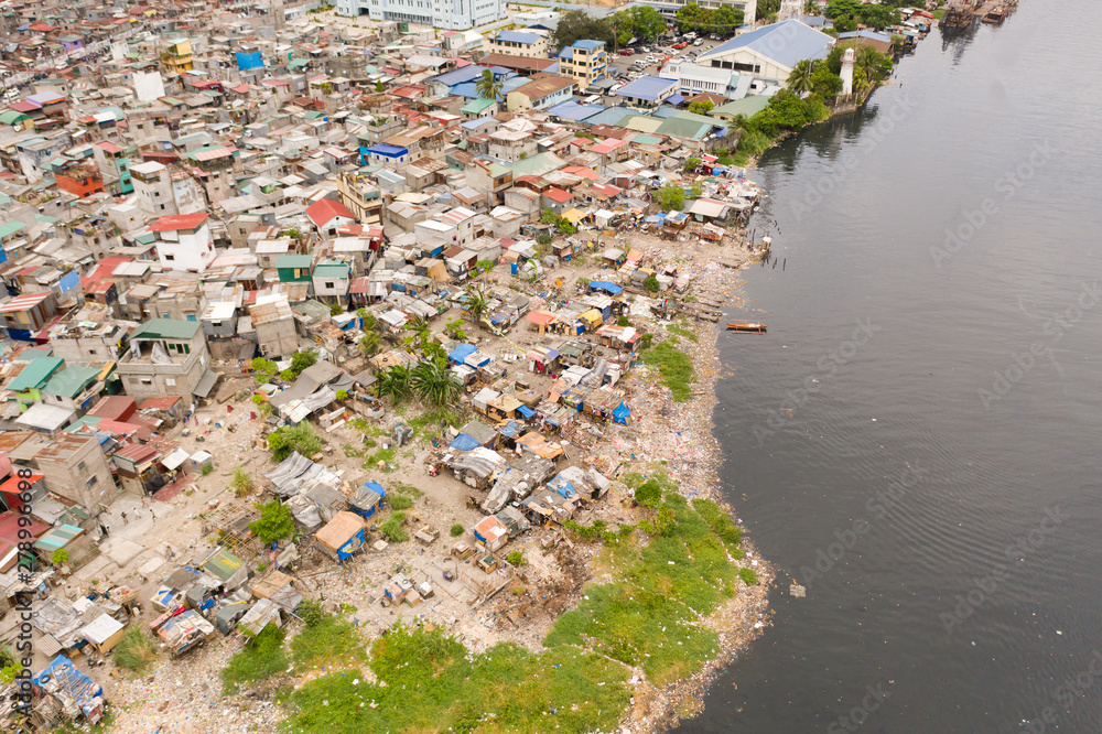 Slums in Manila, a top view. Sea pollution by household waste. Plastic trash on the beach.