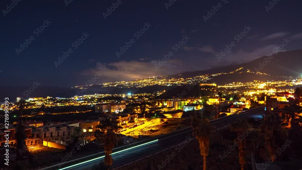 Night time lapse of lights from homes and cars on the highway. Evening view of activity after dark on the island paradise of Tenerife, Spain in the Canary Islands. Motion time lapse. Night time lapse of lights from homes and cars on the highway. Evening view of activity after dark on the island paradise of Tenerife, Spain in the Canary Islands. Motion time lapse.