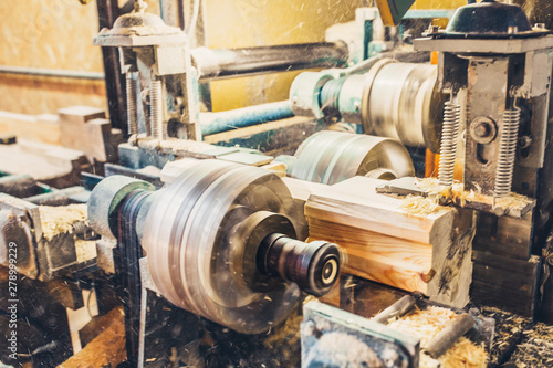 Dusty work - the machine on the production of profiled timber, sawdust flying from under the circular saw