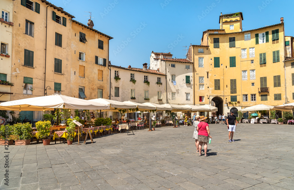 Amphitheater square with restaurants, bars and tourists in old town Lucca, Tuscany, Italy