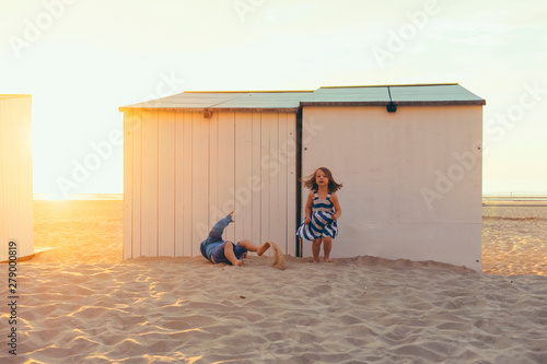 siblins palying together at the beach on sunset time. Childhood  carefree  happiness  holiday destination and family concept