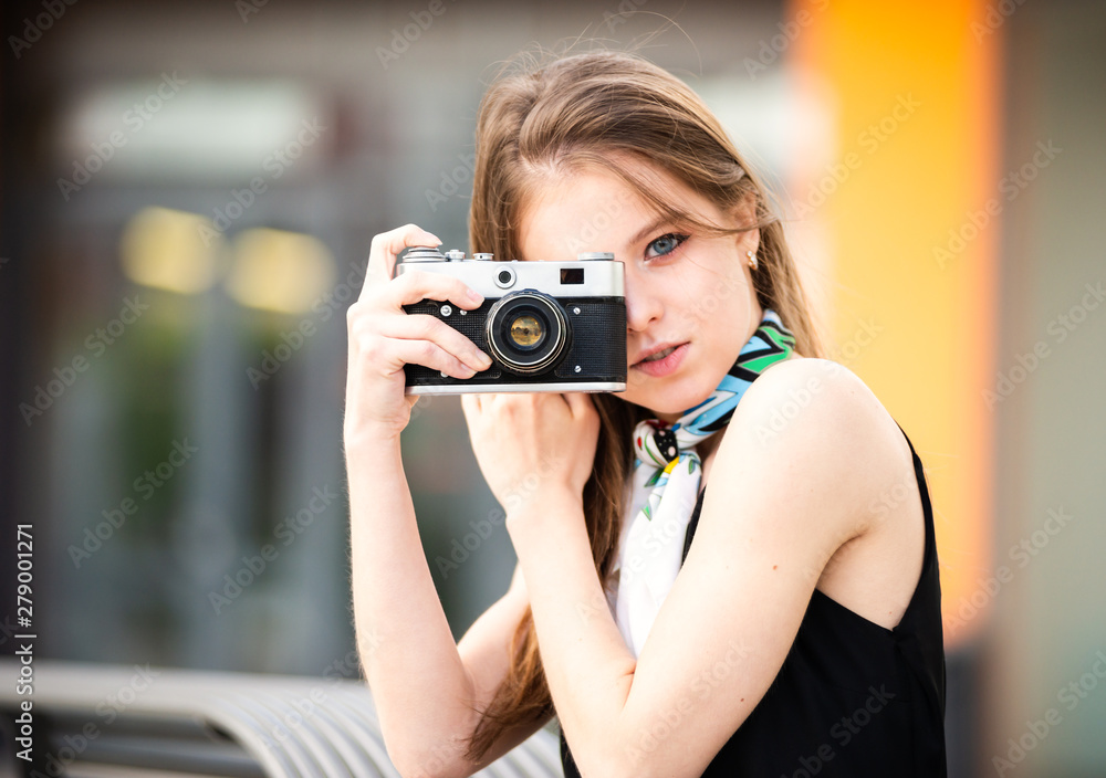 Beautiful girl with vintage camera on the street