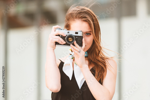 Beautiful girl with vintage camera on the street
