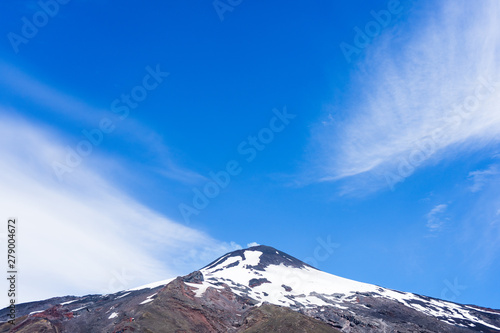 Top center of the Villarica volcano with snow and smoke One of the most active volcanoes in the area.