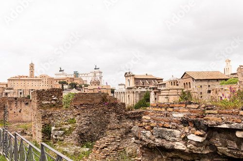 buildings and ruined bricked walls under grey sky in rome, italy