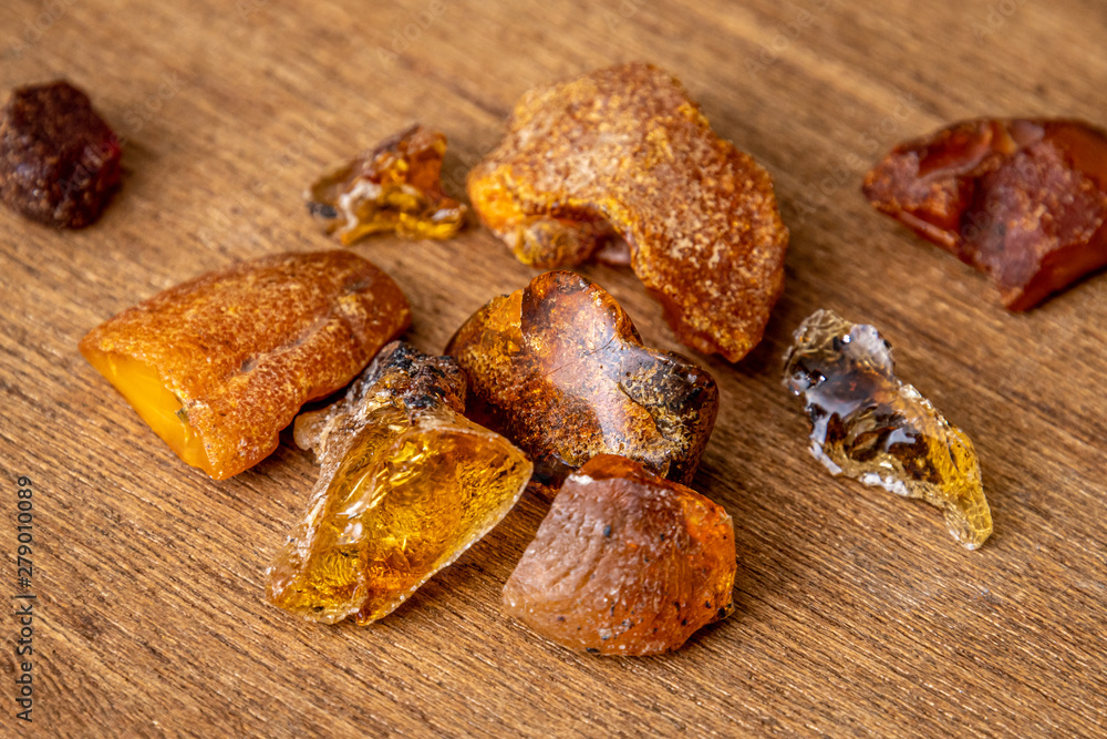 Amber Bernstein collection of beautiful pieces in different tones of yellow orange gold brown and copper on wooden underground Amber Bernstein collection of beautiful pieces in different tones of yellow orange gold brown and copper on wooden underground