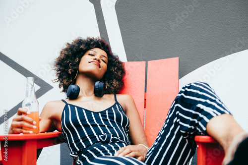 Woman relaxing in red chair with eyes closed