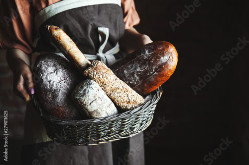 French baguettes in female hands on a black background. homemade baking photo