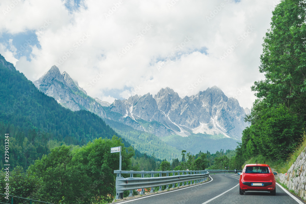 small red car on the road through mountains road trip small red car on the road through mountains road trip