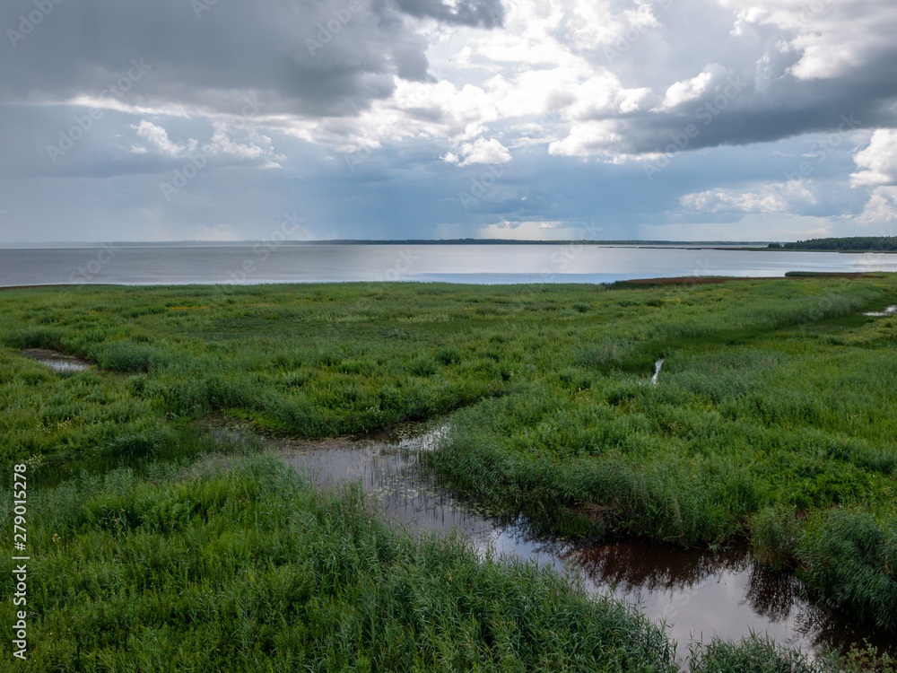 Peaceful beach dunegrass and storm clouds, reflections, Lake Burtnieks, Latvia