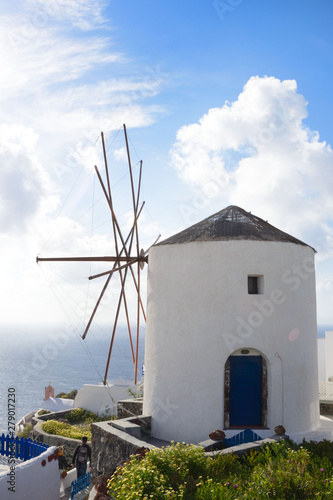 Beautiful island of Santorini, Greece. Traditional white greek houses and windmill against the backdrop of the sea. The city of Oia on the island of Santorini. Greek journey.