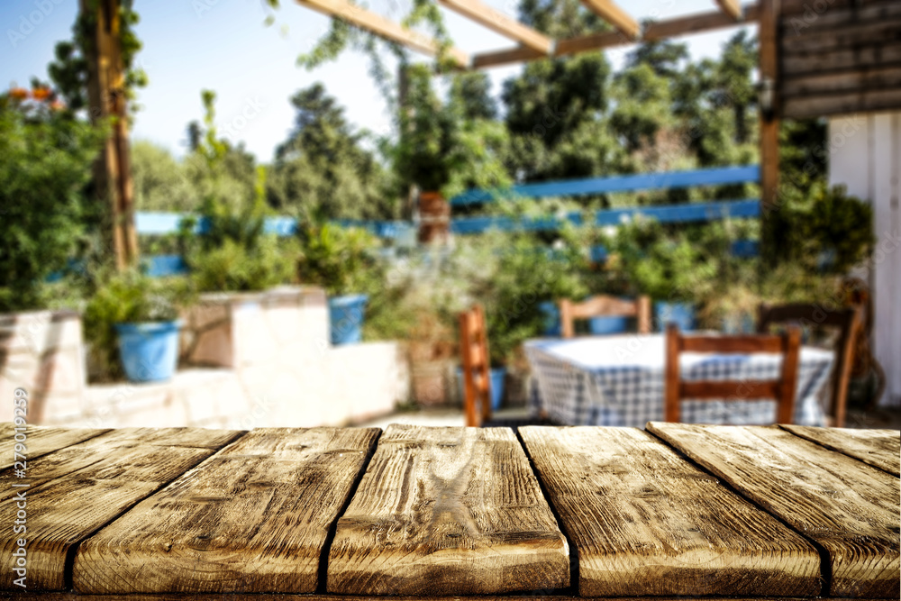 Wooden table backgruond with nature in distance. Blurred garden view.  Forest view in background.