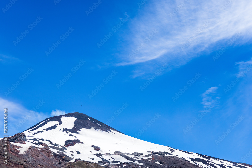 Top right of the Villarica volcano with snow and smoke. One of the most active volcanoes in the area.