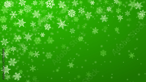 Christmas background of complex blurred and clear falling snowflakes in green colors with bokeh effect