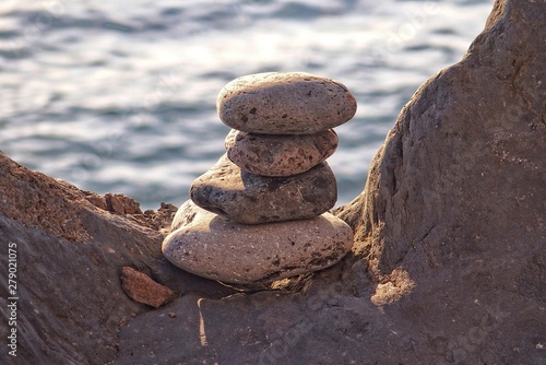 interesting tower made of stones arranged on the shore of the ocean on a warm summer's day