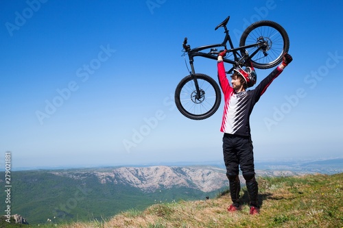Mountain biker holding up a bike