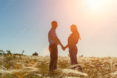 silhouette of two lovers at sunset in the field