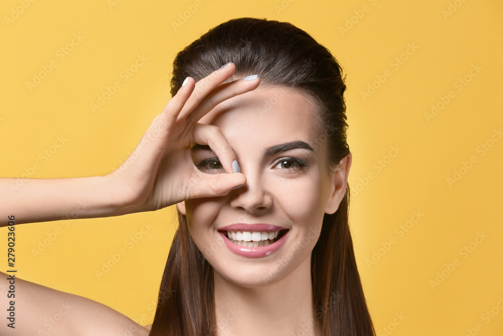 Fototapeta premium Young woman with beautiful eyebrows on color background
